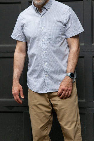 Model standing up wearing short sleeve single needle shirt in color gingham black and white