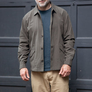 Male model wearing painter shirt in dark green, grey t-shirt and khaki pants